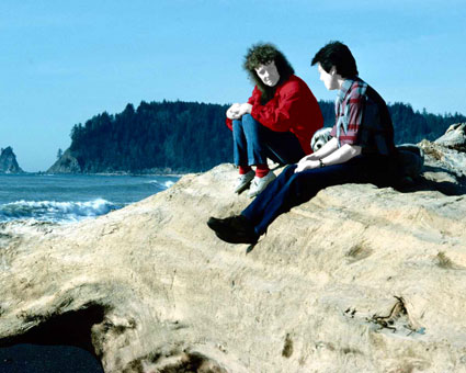 Zwei Personen sitzen auf Felsvorsprung am Meer